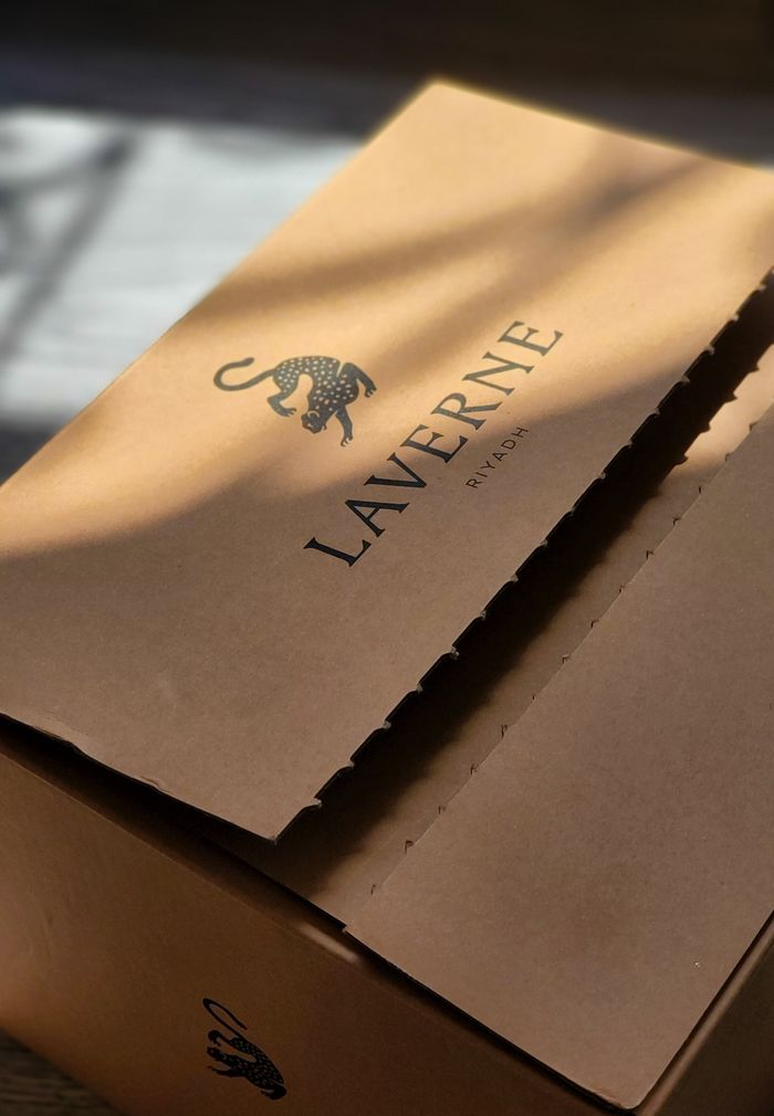 Close-up of Laverne cardboard box with artistic leopard logo, bathed in gentle sunlight.